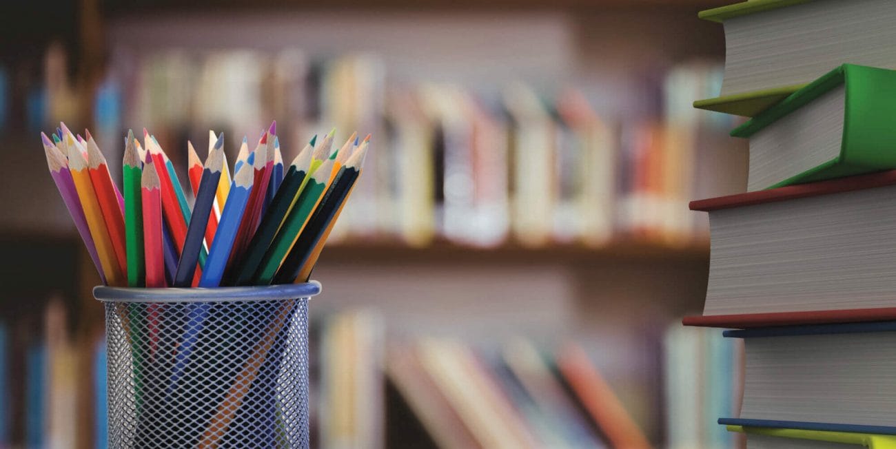 Digital composite of Pencils and stack of books with library background Digital composite of Pencils and stack of books with library background